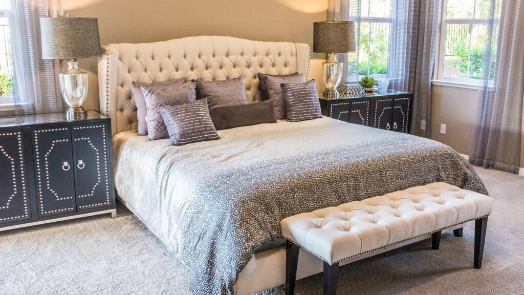 Bright bedroom with sunlight streaming through window onto a made bed