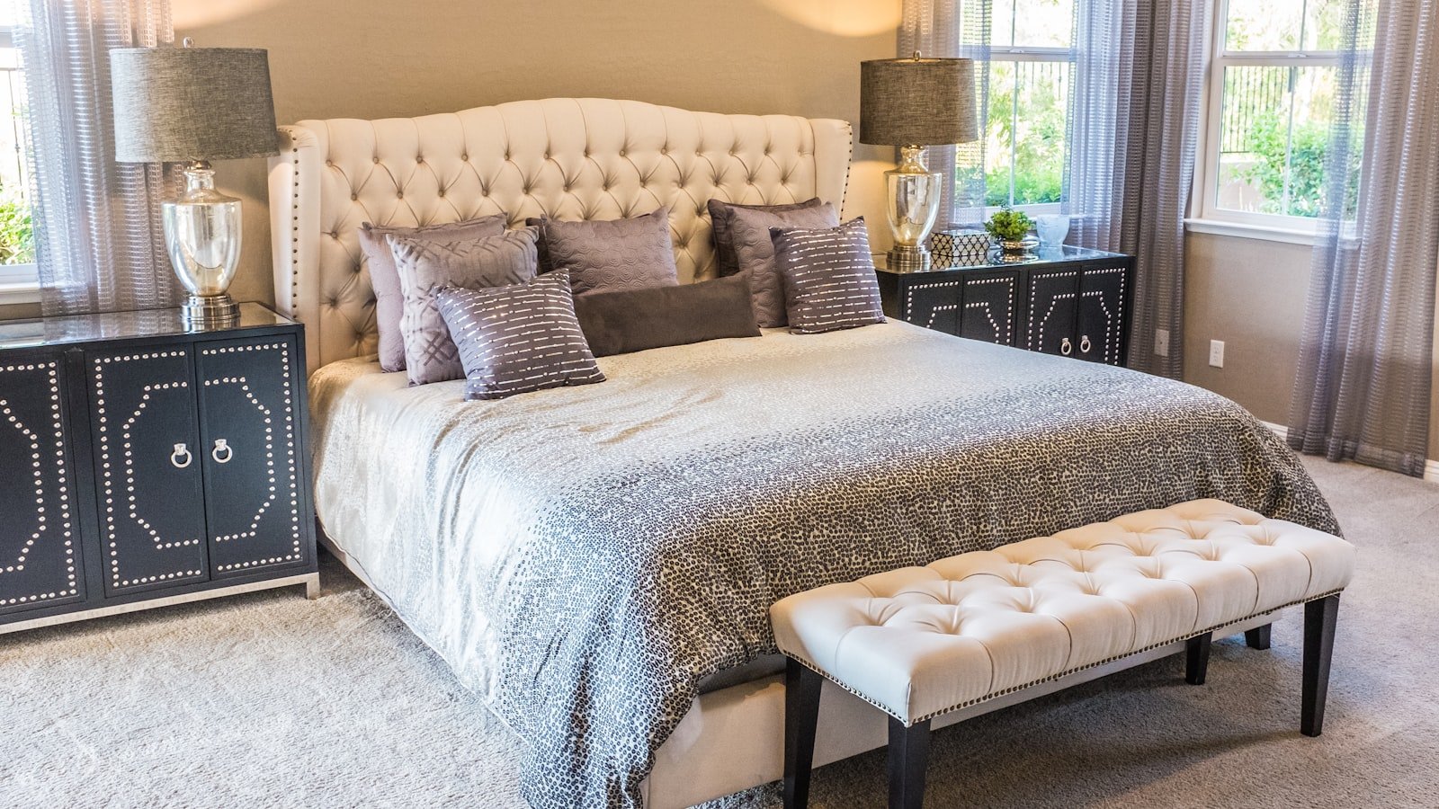 Bright bedroom with sunlight streaming through window onto a made bed